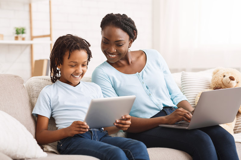 afro-mom-and-daughter-doing-school-homework-on-sof-QHHEQDH.jpg